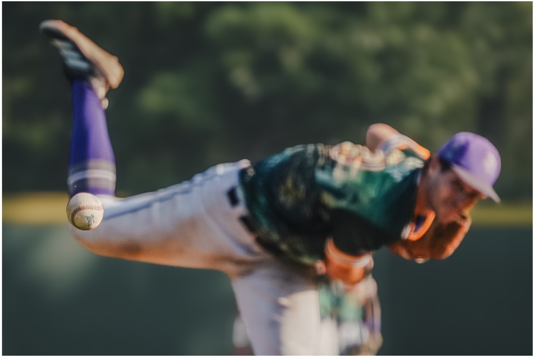 NECBL pitcher finishing his delivery with the baseball in the foreground